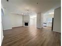 Bright living room with fireplace, modern light fixture, and wood floors at 358 Azalea Cir, Cumming, GA 30040