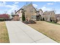 Spacious home featuring a long driveway and mature landscaping, showcasing the beautiful brick architecture at 6040 Boulder Bluff Dr, Cumming, GA 30040