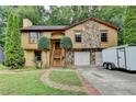 Charming home featuring a stone accent exterior, two-car garage and lush green lawn with mature landscaping at 1922 Marshes Glenn Dr, Norcross, GA 30071