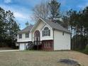 Exterior side view of a well-maintained home featuring a manicured lawn and mature trees in a serene setting at 6334 Milo Dr, Austell, GA 30168
