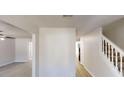Bright hallway featuring hardwood floors and staircase with white railings at 6643 Hill Creek Cv, Lithonia, GA 30058