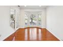 Bright living room with hardwood floors, bay window, and a white door at 3242 Monarch Pine Nw Dr, Peachtree Corners, GA 30071