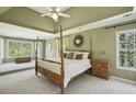 Spacious bedroom featuring a tray ceiling, carpeted floors, and large windows at 535 Cameron Manor Way, Atlanta, GA 30328