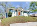 Charming home featuring an inviting orange front door, blue and white exterior, and landscaped front yard at 1497 Rogers Sw Ave, Atlanta, GA 30310