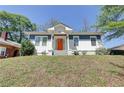 Charming home featuring an inviting orange front door, blue and white exterior, and landscaped front yard at 1497 Rogers Sw Ave, Atlanta, GA 30310
