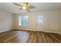 Bright living room featuring durable wood-look floors, ceiling fan, and glass paneled exterior door at 8409 Carlington Ln, Jonesboro, GA 30236