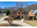 Beautiful two-story brick home with manicured landscaping, a spacious driveway, and a classic roof design at 1540 Turtle Pond Dr, Hoschton, GA 30548