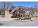 Charming brick home on a corner lot with a well-maintained lawn, showcasing curb appeal and a spacious driveway at 1540 Turtle Pond Dr, Hoschton, GA 30548