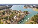 Aerial view of a waterfront property with a private dock, surrounded by lush greenery and serene lake waters at 7410 Fields Dr, Cumming, GA 30041