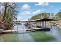 Picturesque view of a private boat dock on a serene lake, offering waterfront living and recreational opportunities at 7410 Fields Dr, Cumming, GA 30041
