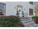Elegant front entry featuring stone steps, a decorative wreath, and manicured bushes, exuding sophistication and charm at 3471 Greyfield Nw Ln, Kennesaw, GA 30152