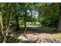 Beautifully landscaped front yard featuring a stone water feature and mature trees at 59 Woodlawn Dr, Marietta, GA 30067
