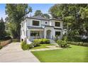 View of house exterior featuring lovely lawn, landscaping, and a driveway at 159 E Wesley Ne Rd, Atlanta, GA 30305