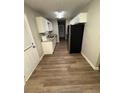 Efficient kitchen featuring white cabinets, stainless steel appliances, and wood flooring at 9161 Fairway Ct, Riverdale, GA 30274