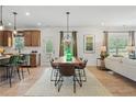 Open-concept dining area with modern light fixtures, hardwood floors, and access to the kitchen at 106 Asher Dr, Carrollton, GA 30116