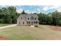 Beautifully landscaped home with a charming front porch and well-manicured lawn at 3292 Mill Forest Sw Dr, Conyers, GA 30094