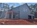 Rear view of new home construction with a covered patio, spacious backyard, and attached garage at 3292 Mill Forest Sw Dr, Conyers, GA 30094