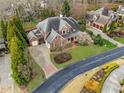 Aerial view of a beautiful brick home featuring lush landscaping and a circular driveway at 3821 Teesdale Ct, Atlanta, GA 30350