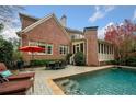 A backyard oasis with a sparkling pool, outdoor dining area, and cozy lounge chairs at 3821 Teesdale Ct, Atlanta, GA 30350