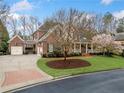 Charming brick two-story home with manicured lawn, mature trees, and welcoming front porch at 3821 Teesdale Ct, Atlanta, GA 30350