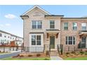 Charming brick townhome featuring a covered entrance, manicured lawn, and inviting curb appeal at 3260 Bennett Creek Ln, Suwanee, GA 30024