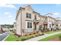 View of a row of new brick townhomes with manicured lawns and sidewalks in a modern community at 3260 Bennett Creek Ln, Suwanee, GA 30024
