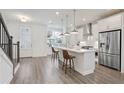Modern kitchen with stainless steel appliances, white cabinetry, an island, and pendant lighting at 3260 Bennett Creek Ln, Suwanee, GA 30024