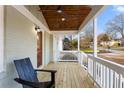 Inviting front porch with stained wood ceiling and flooring, featuring a comfortable seating area at 1020 Pinedale Se Dr, Smyrna, GA 30080