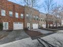 View of brick townhomes with attached garages and driveways at 121 Riverwatch Ct, Canton, GA 30114