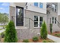 Inviting townhome entrance with gray brick steps, black metal railings, and manicured landscaping at 2567 Astaire Ct, Atlanta, GA 30318
