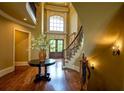 Grand foyer with hardwood floors, curved staircase, and a large arched window at 3299 Carmichael Pl, Duluth, GA 30097