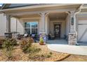 Inviting front porch with stone accents, comfortable seating, and a beautifully landscaped garden area at 2638 Songbird Ln, Grayson, GA 30017
