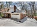 Close-up of two-car garage, with a spacious driveway and an outdoor seating area at 2242 Greencrest Ne Dr, Atlanta, GA 30345