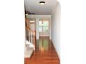 Spacious hallway with hardwood floors, white trim, stairs, and natural light from large window at 3356 Sardis Bend Dr, Buford, GA 30519