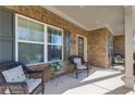 Inviting covered porch with comfortable wicker seating, perfect for relaxing and enjoying the outdoors at 3475 Summerlin Pkwy, Lithia Springs, GA 30122