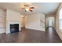 Bright living room with fireplace, ceiling fan, and staircase at 3879 Brockenhurst Dr, Buford, GA 30519