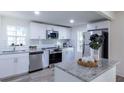 Modern kitchen with stainless steel appliances, granite countertops, and white cabinetry at 2949 Pearl St, East Point, GA 30344