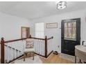 Welcoming foyer with a charming chair, decor and front door with sidelight window at 353 Chateauguay Dr, Ellenwood, GA 30294