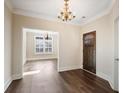 Elegant foyer with a dark wood door, chandelier, and beautiful hardwood floors at 1011 Stillington Way, Kennesaw, GA 30152