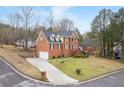 Corner view showcasing the brick home's curb appeal, long driveway and landscaping at 1811 Lake Cove Sw Dr, Atlanta, GA 30331