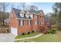 Side angle of brick home with an attached garage and beautifully maintained yard at 1811 Lake Cove Sw Dr, Atlanta, GA 30331