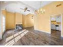 Sun-lit living room with high ceilings, hardwood floors, fireplace, and an adjacent view of the kitchen at 303 Brandywine Cir, Atlanta, GA 30350