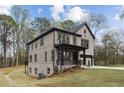 Exterior view of a home with a walkout basement, brick facade, and large windows overlooking a wooded lot at 346 Langford Dr, Norcross, GA 30071