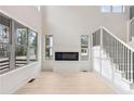 Bright living room featuring a modern fireplace, large windows, and a staircase with black railings at 346 Langford Dr, Norcross, GA 30071