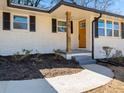 Close-up of the home's entrance, highlighting the white brick exterior, porch, and updated landscaping at 1937 Joseph Ct, Decatur, GA 30032