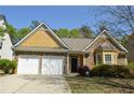 Charming home featuring stone and shingle accents, well-manicured landscaping, and an attached two-car garage at 5250 Fieldgate Ridge Dr, Cumming, GA 30028