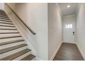 Bright entryway with stairs, wood-look floors, and white front door at 255 Depot Landing Rd # 38, Auburn, GA 30011