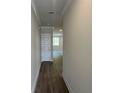 Hallway with a neutral color palette, wood floors, and a white door that adds brightness to the space at 255 Depot Landing Rd # 38, Auburn, GA 30011