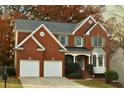 Beautiful brick home featuring a two-car garage, classic architecture, and lush landscaping at 912 Tanners Point Dr, Lawrenceville, GA 30044