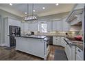 Bright kitchen features white cabinetry, stainless steel appliances, a central island, and elegant granite countertops at 2160 Kensington Gates Nw Dr, Kennesaw, GA 30152